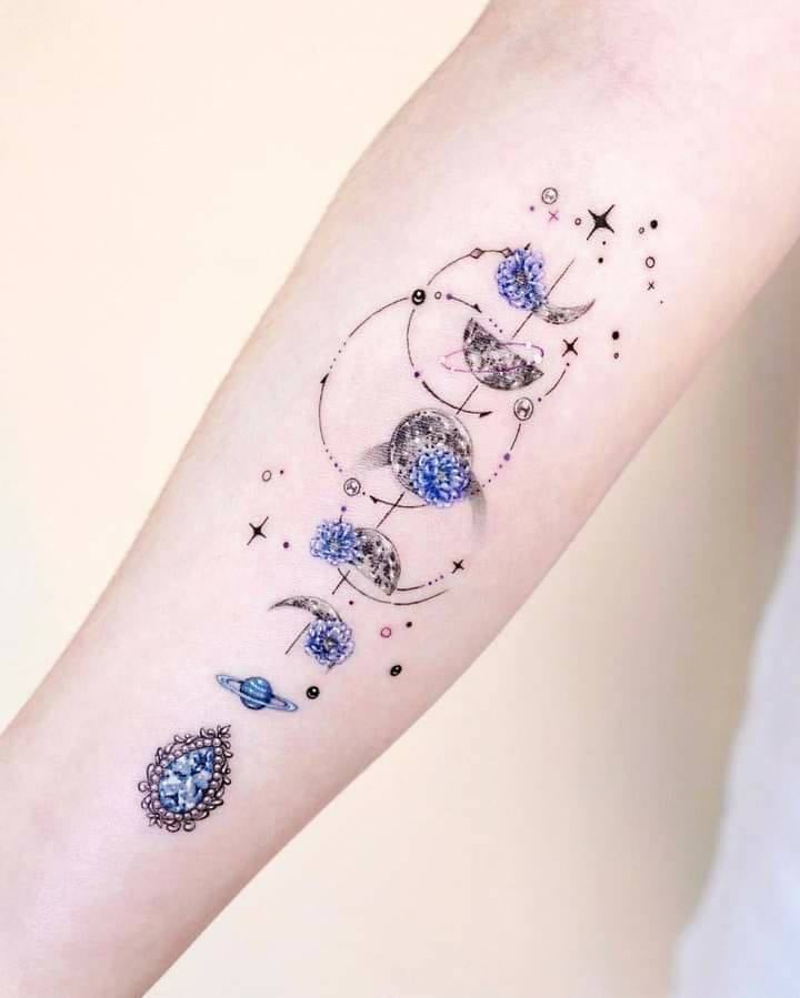 1 TOP 1 Tatuagens Femininas Realmente Lindas Parte 2 Fases lunares em pequenas e delicadas flores azuis no braço, gema de topázio celestial