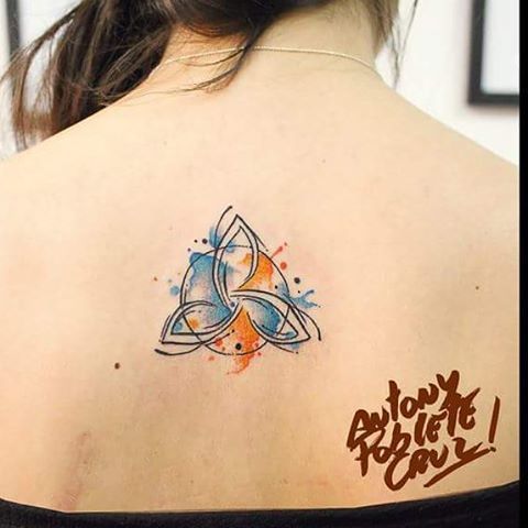 2 Tatuaje de Simbolo Celta de Triqueta en acuarela celeste y anaranjado con circulo en espalda mujer