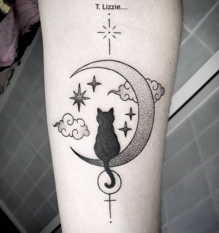 13 Tattoos of Cats sitting on a black crescent with stars and clouds cross below forearm
