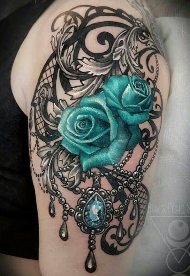 17 Tatuaje de Rosas Celestes intenso con adornos grises de esferas de acero y gema celeste en brazo