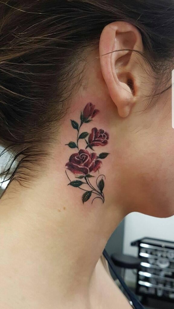 17 rote Rosen Tattoo hinter dem Ohrzweig mit Blättern und Zweig