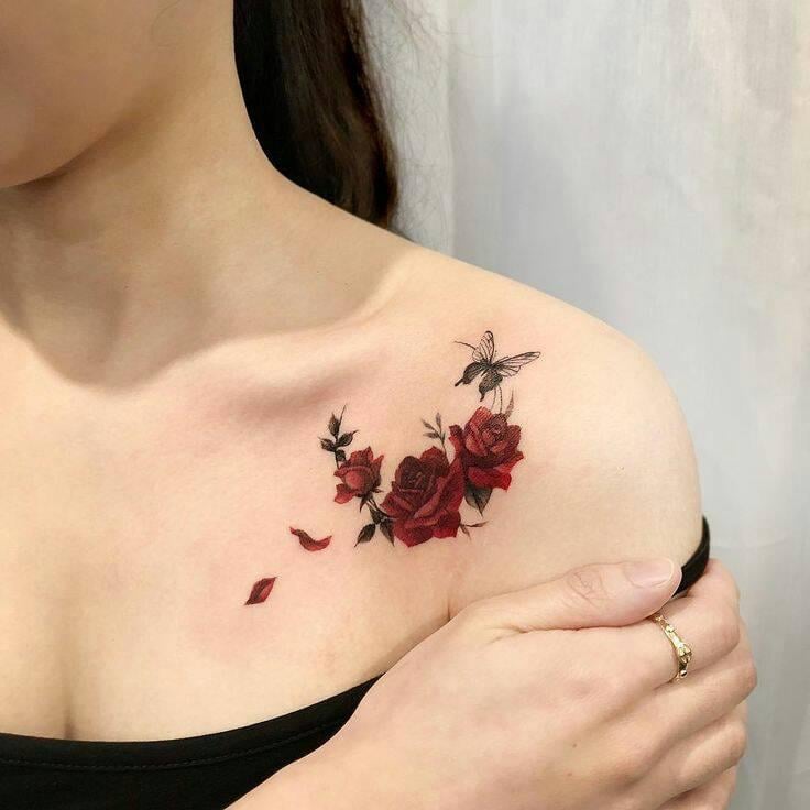 17 Tatuagem de três rosas vermelhas com uma borboleta no ombro, pétalas caindo
