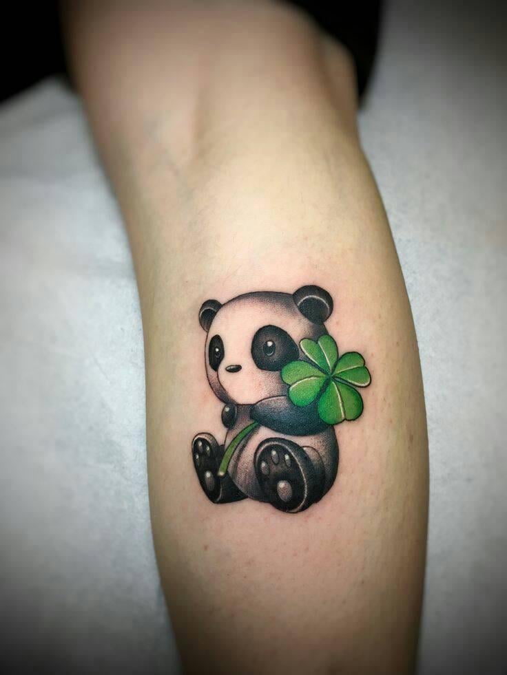 33 Tatuajes de Panda Negro con Trebol Verde en la mano Antebrazo