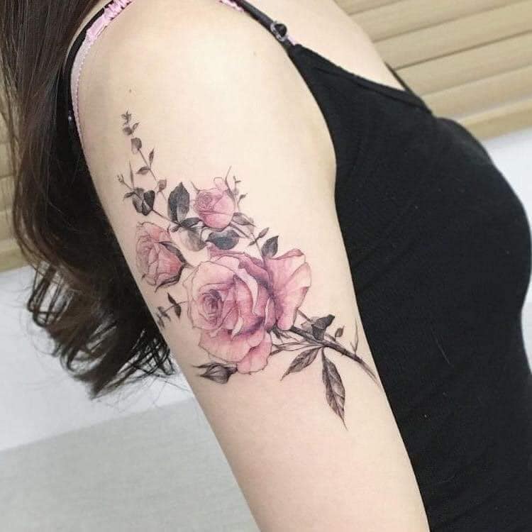 51 Tatuagem de Rosas Rosas com folhas e caule no braço