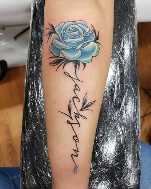 53 tatuaggi floreali con nomi sul gambo Rosa azzurra con il nome Jackson sull'avambraccio