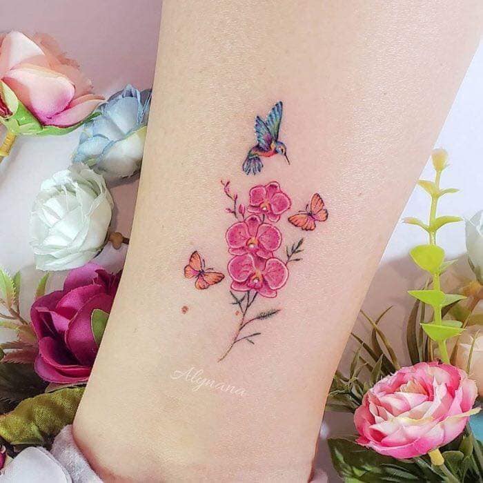 63 tatuagens de beija-flores na panturrilha com flores rosa e galho de borboletas imperadores laranja