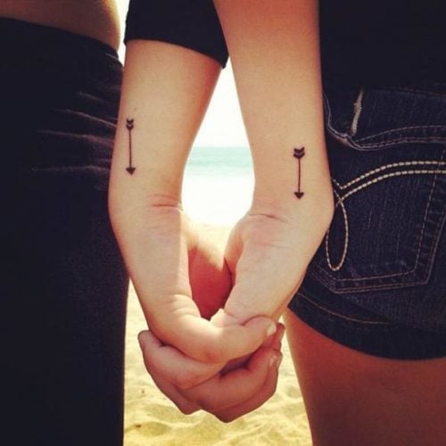Tatuagens pequenas e complementares para casais nos pulsos Duas flechas iguais