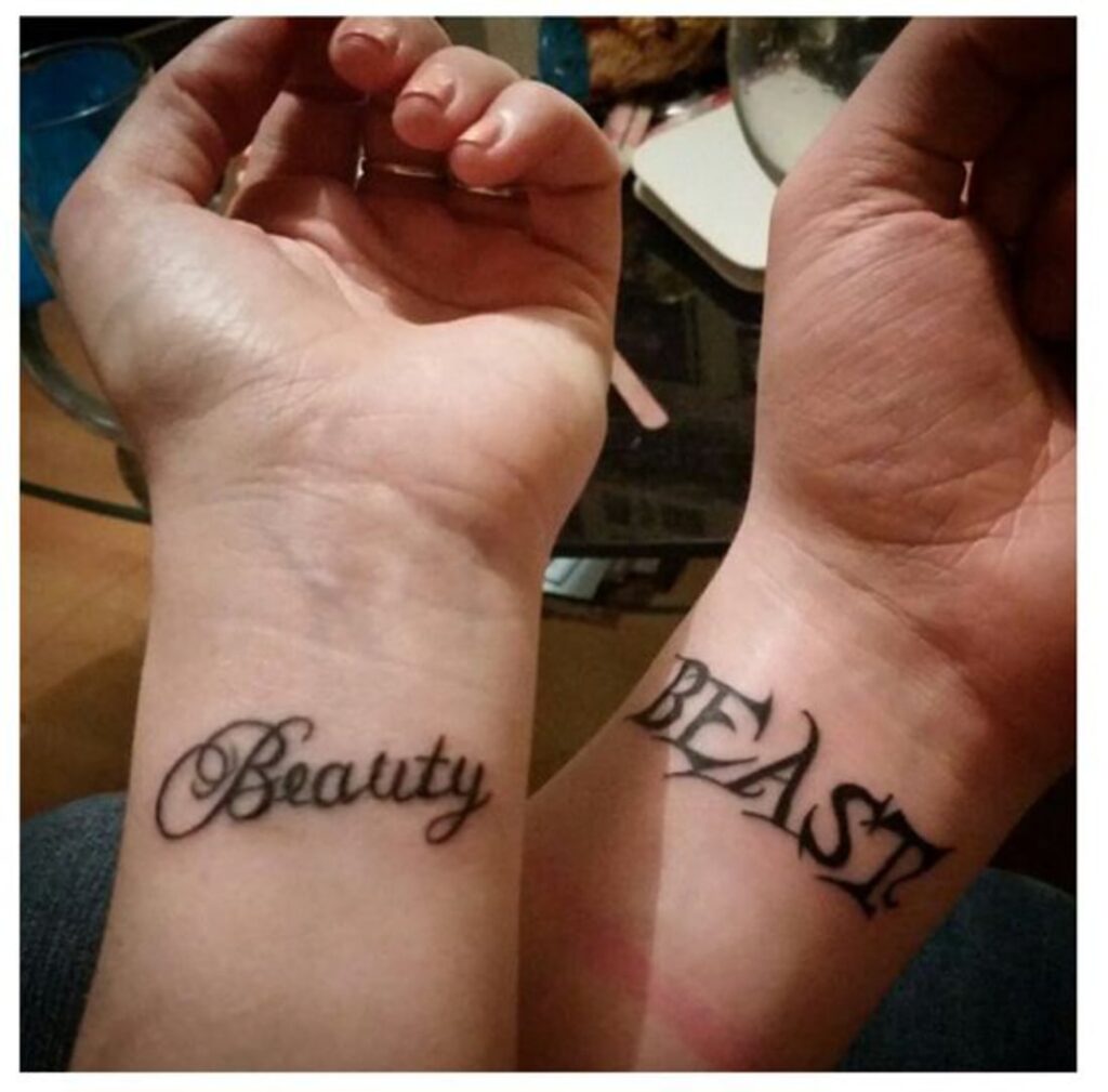 Piccoli tatuaggi complementari per coppie sui polsi, scritta su una Bella Bella e sull'altra Bestia Bestia