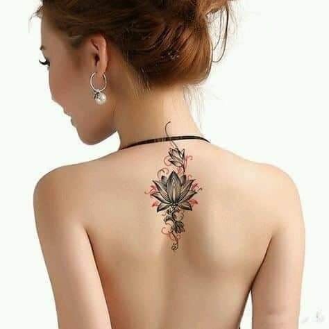 105 Rückentattoo Frau mit schwarzer Lotusblume in der Mitte der Schulterblätter und roten Linien