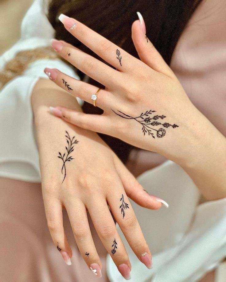13 Tatuajes para Manos delicadas ramitas negras con florcitas en varios dedos y dorso
