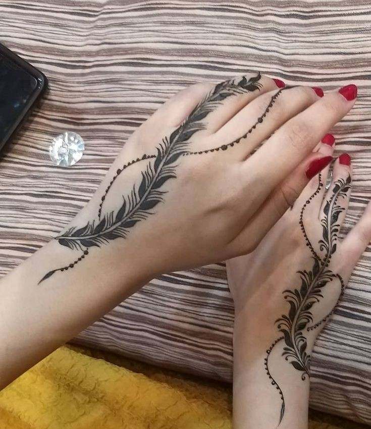 17 Tatuajes para Manos pluma hasta el dedo anular en ambas manos y adornos de henna