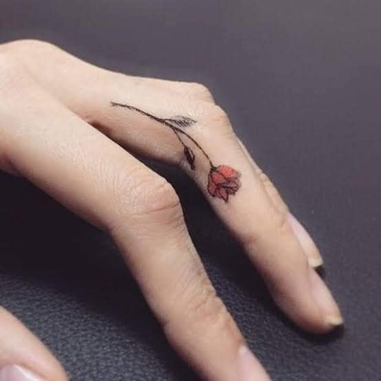 46 Tattoos auf den Fingern der Hände, kleine Rose mit Rot an der Seite des Mittelfingers