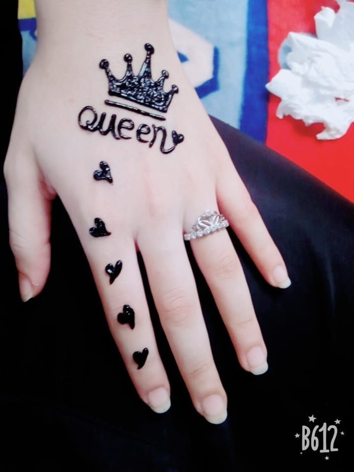 6 Tatuajes para Manos detalle en henna que dice queen en el dorso de la mano y corazones en el dedo