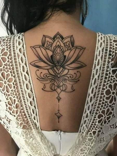 92 Tattoo-Rückenfrau mit großer schwarzer Lotusblume in der Mitte der Schulterblätter