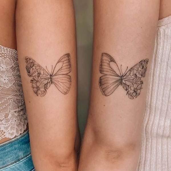 0 Tatuajes de Mariposas para parejas amigas duo contorno claro en brazo mitad flores