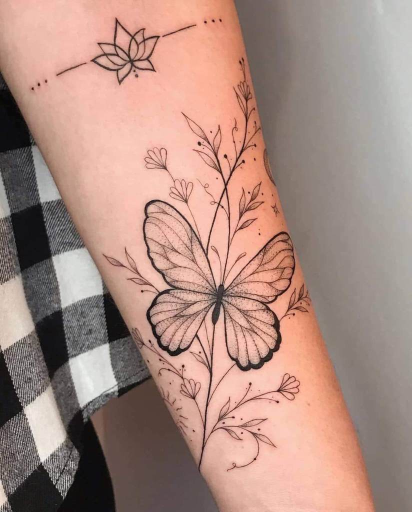32 tatuagens de borboletas no antebraço com linhas pretas definidas, folhas e flores e uma pequena flor de lótus