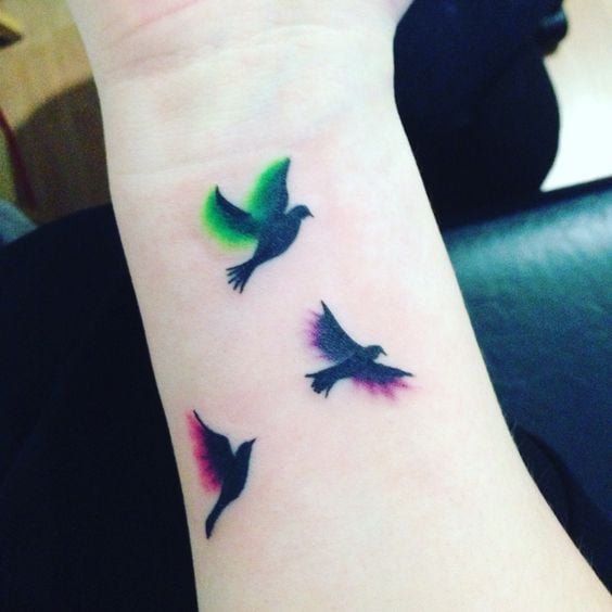 1 TOP 1 Tre tatuaggi di uccelli e colori neri sul polso con sfocatura di colore verde e rosso