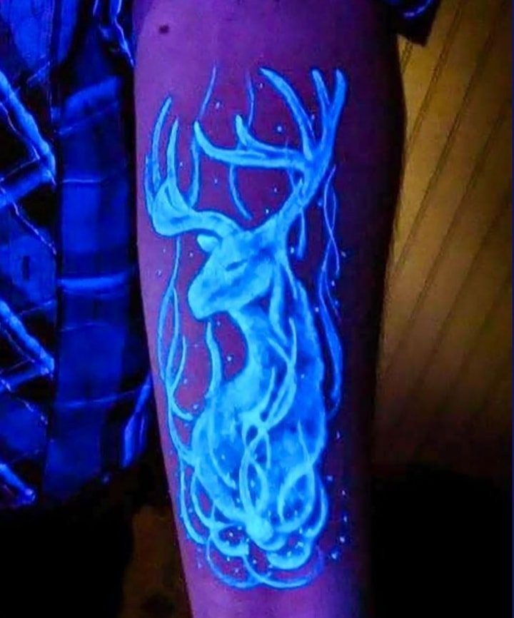 28 tatuaggi di cervo fluorescenti in azzurro sull'avambraccio