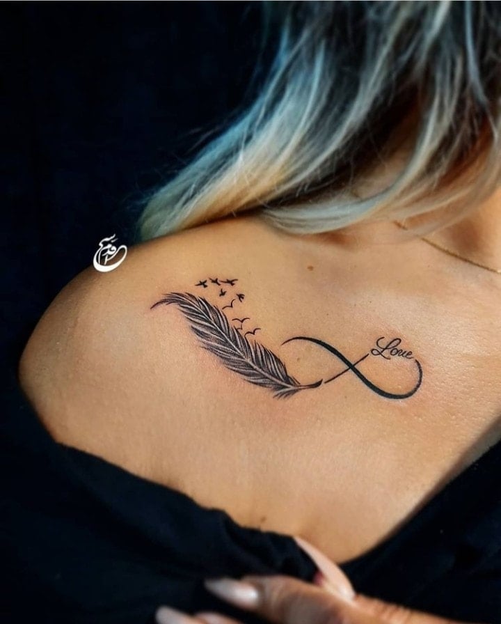 41 wunderschöne Tattoos für Frauen Unendlichkeit am Schlüsselbein mit Feder und fliegenden Vögeln. Schwarzes Wort „Liebe“.