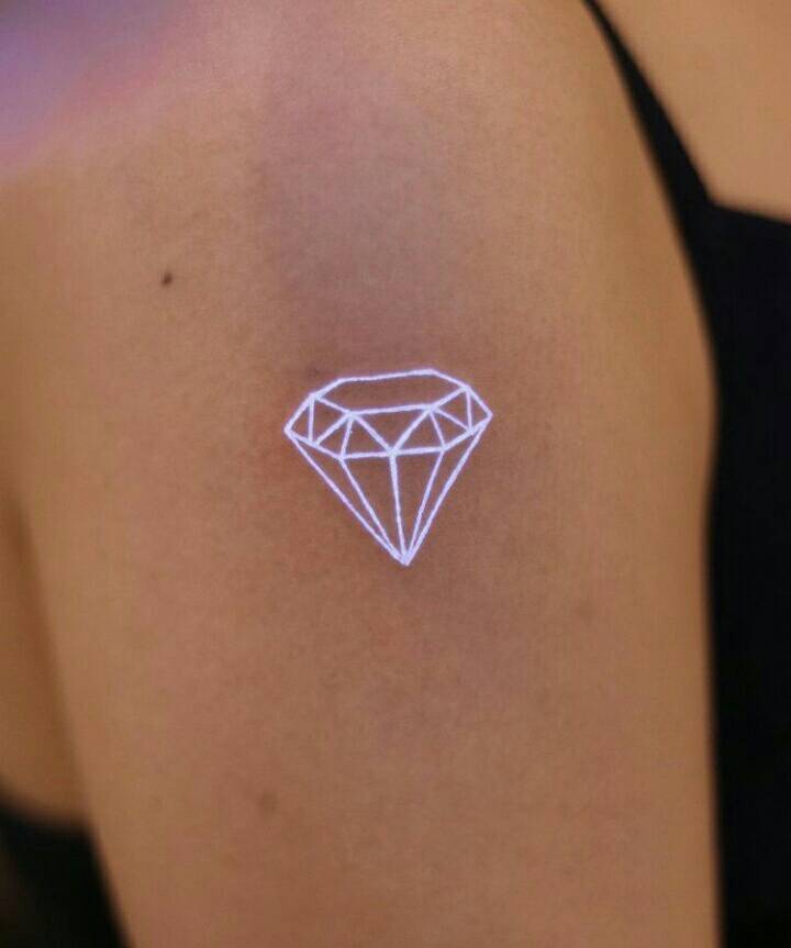 46 UV-Tattoos mit Diamanten aus weißer Tinte in 3D, aufgebaut aus Polygonen auf dem Arm