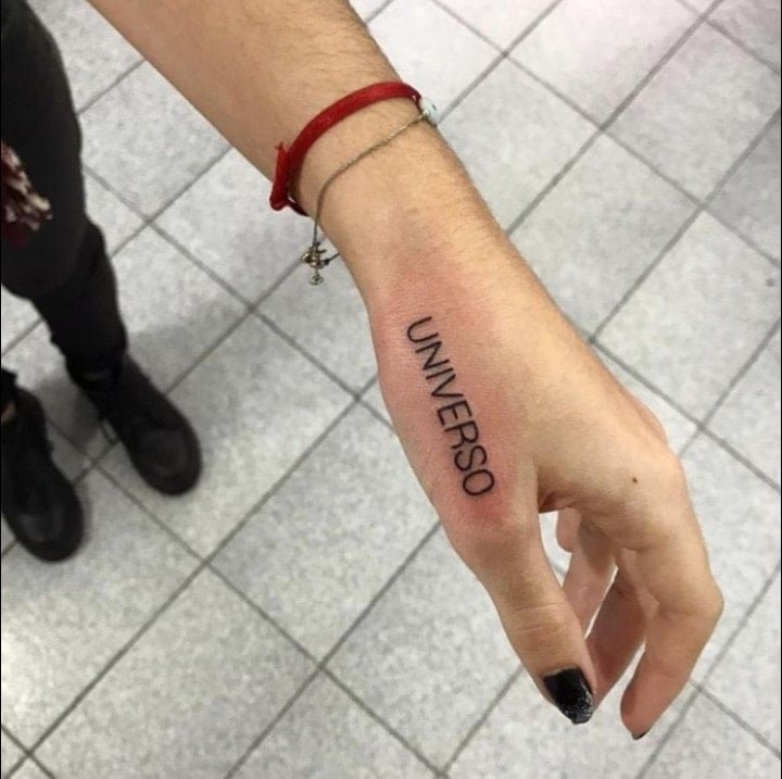 8 Beautiful Tattoos in Women on the hand word Universe above the middle finger