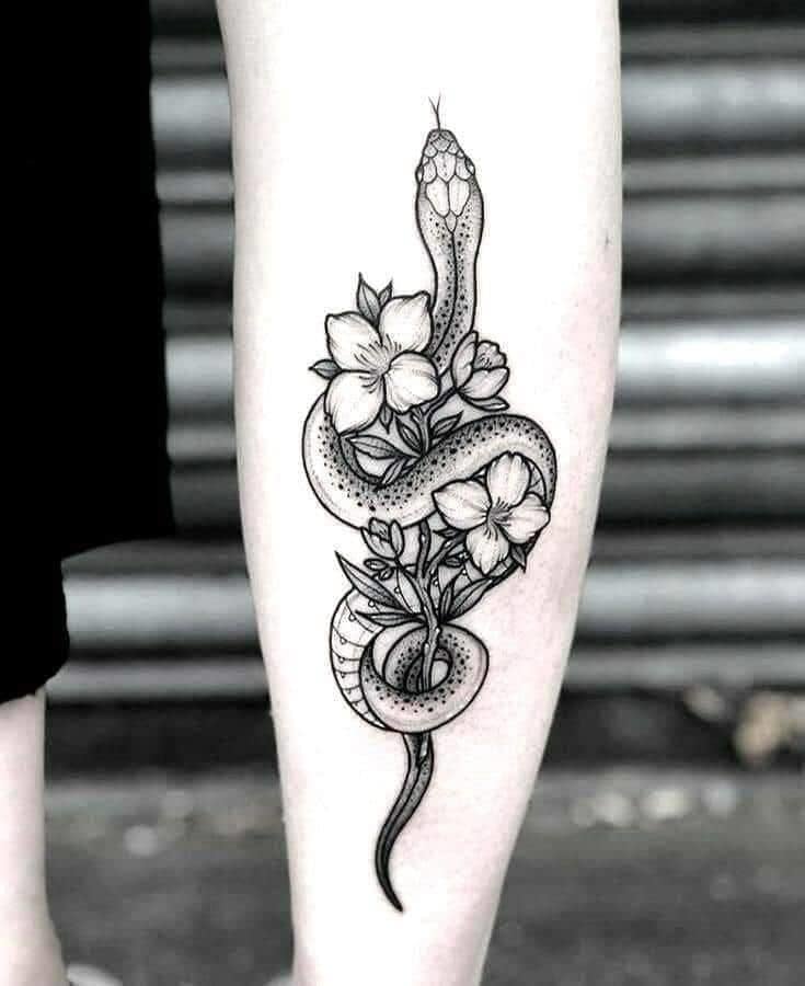 Tatuajes de Vivoras Serpientes Mujer en contorno negro con flores en brazo