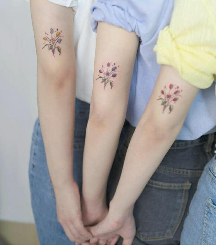 Tatuaggi per amici, sorelle, coppie, rametti di fiori in tre sorelle sul braccio