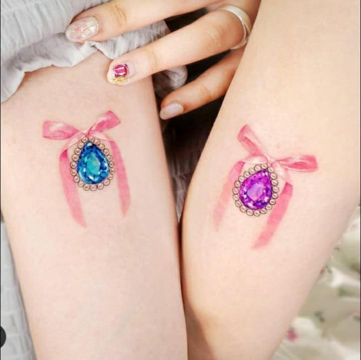 Tattoos für Freunde, Schwesternpaare, Affe mit Juwel, ein hellblauer Topas, ein anderer violetter Amethyst mit Perlen und ein Affe auf dem Arm der Schwestern