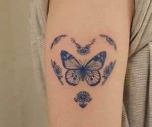 16 tatuagens de corações borboleta azul no braço cercada por coração com ornamentos