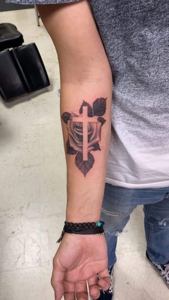 28 Kreuz-Tattoos auf dem kleinen Unterarm mit einer Rose im Hintergrund und einem darüberliegenden Kreuz ohne Füllung