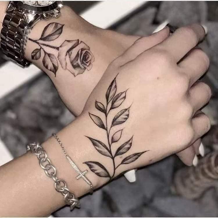 44 Tattoos auf der Hand Schwarze Zweige in einem und rosa Blume in einem anderen