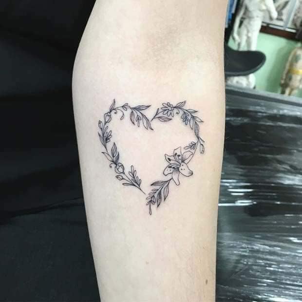 6 tatuaggi a forma di cuore sull'avambraccio con fiori e ramoscelli