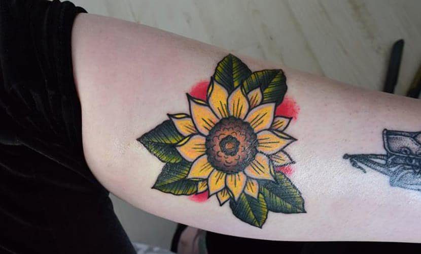 61 Tatuaggi di girasole sul braccio con foglie verdi