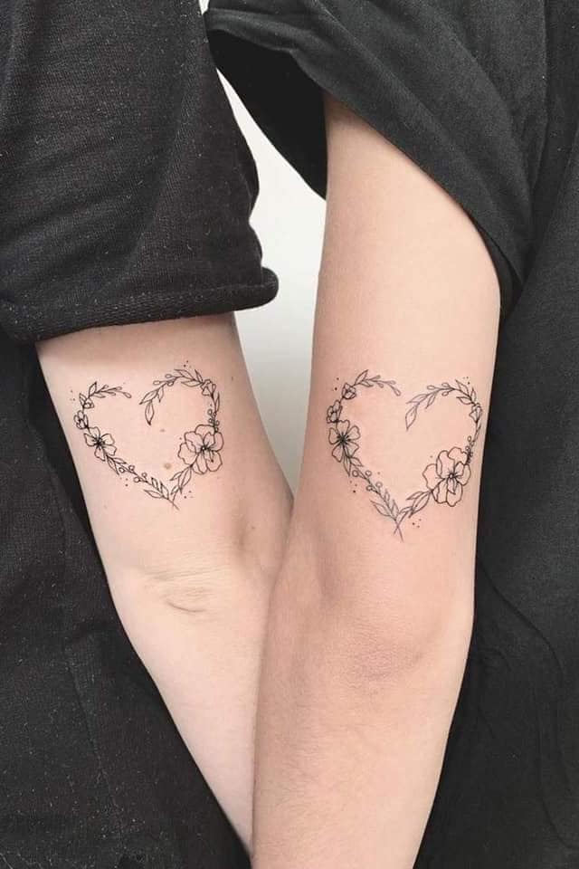 8 tatuaggi a cuore per coppie sul braccio con fiori e ramoscelli