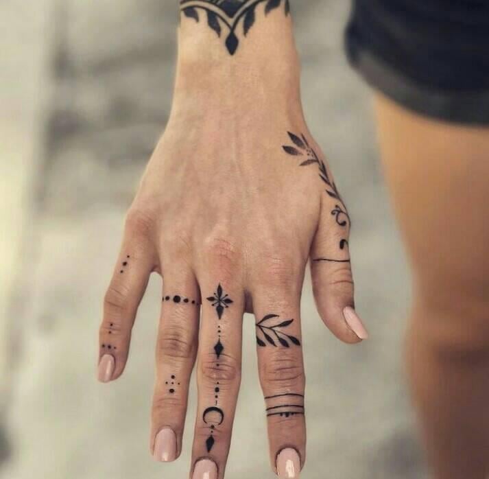 8 Tatuagens nas Mãos Detalhes nos dedos da lua, flecha, cruz, galhos com folhas em preto