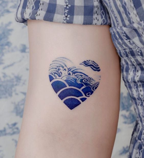 Tatouages de coeurs avec la mer à l'intérieur bleu sur le bras
