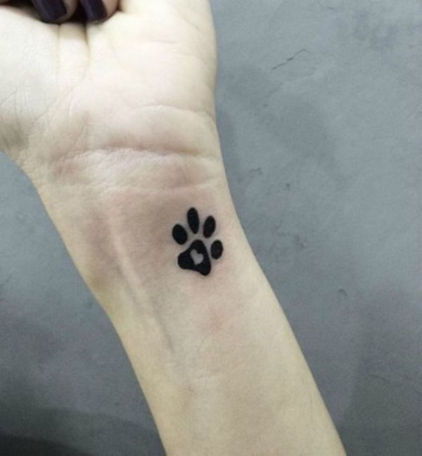 Stampa minimalista della zampa del tatuaggio del cane sul polso