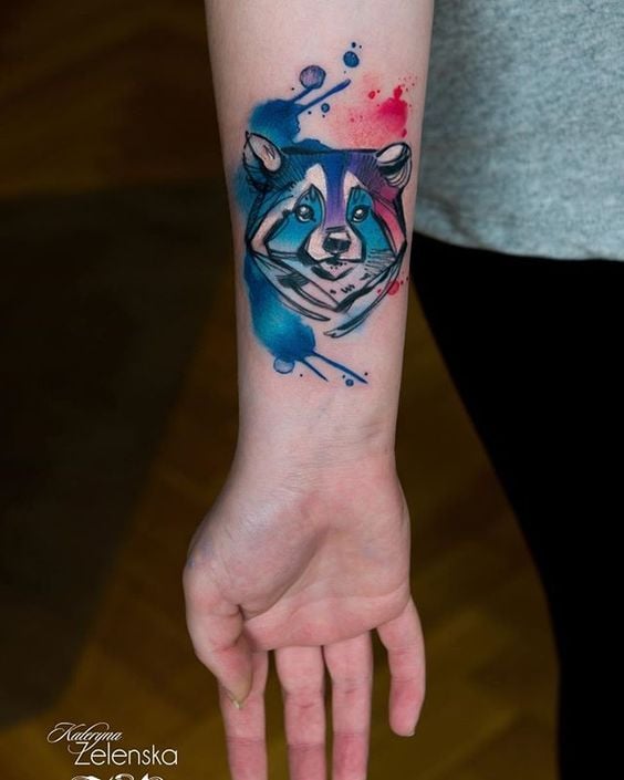 Tatuaggi di lupo ad acquerello con una faccia geometrica come un rombo sull'avambraccio