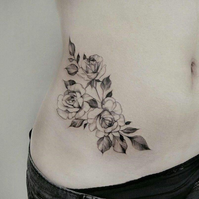 13 tatuagens no abdômen Três flores pretas na lateral