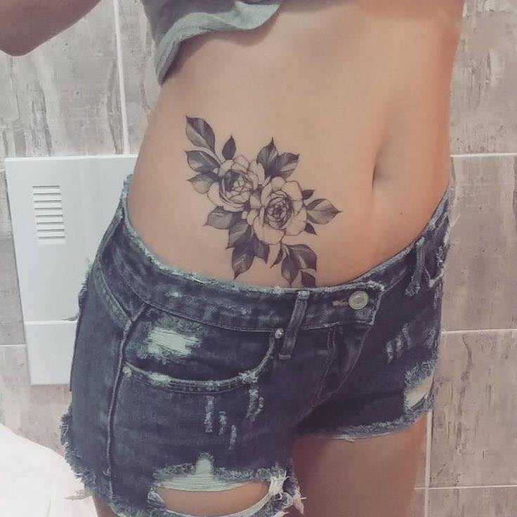7 tatuagens de abdômen Buquê de duas flores pretas e folhas pretas na lateral