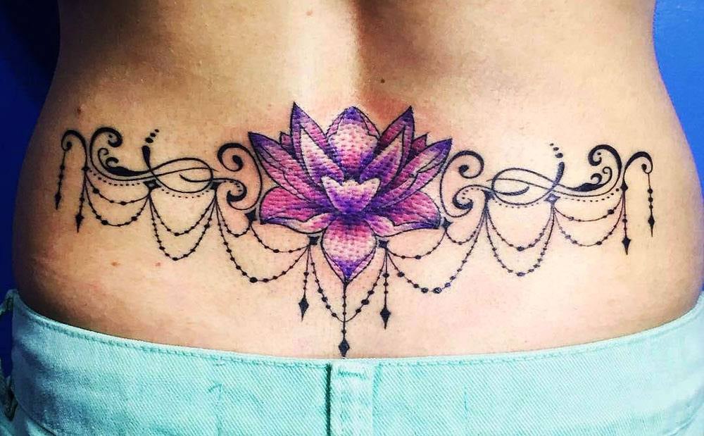 Tatuajes en espalda baja Flor de loto Violeta o purpura con adornos tipo llamadores de angeles