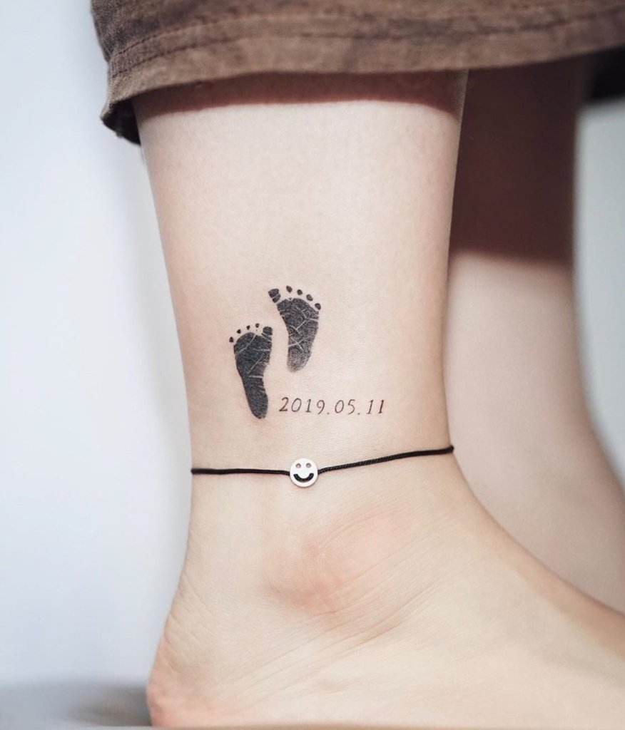 1 TOP 1 Baby Foot Tattoos with date on small black calf