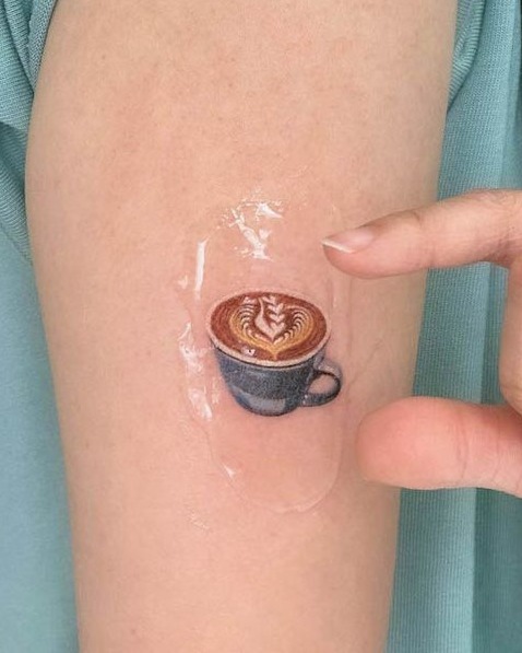 12 Tatuajes para Amantes del Cafe en color con espuma formando dibujo en antebrazo 12 Tatuajes para Amantes del Cafe en color con espuma formando dibujo en antebrazo