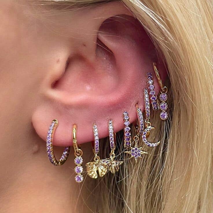 139 Ear Piercings a series of hoops with violet stones and golden gold metal color