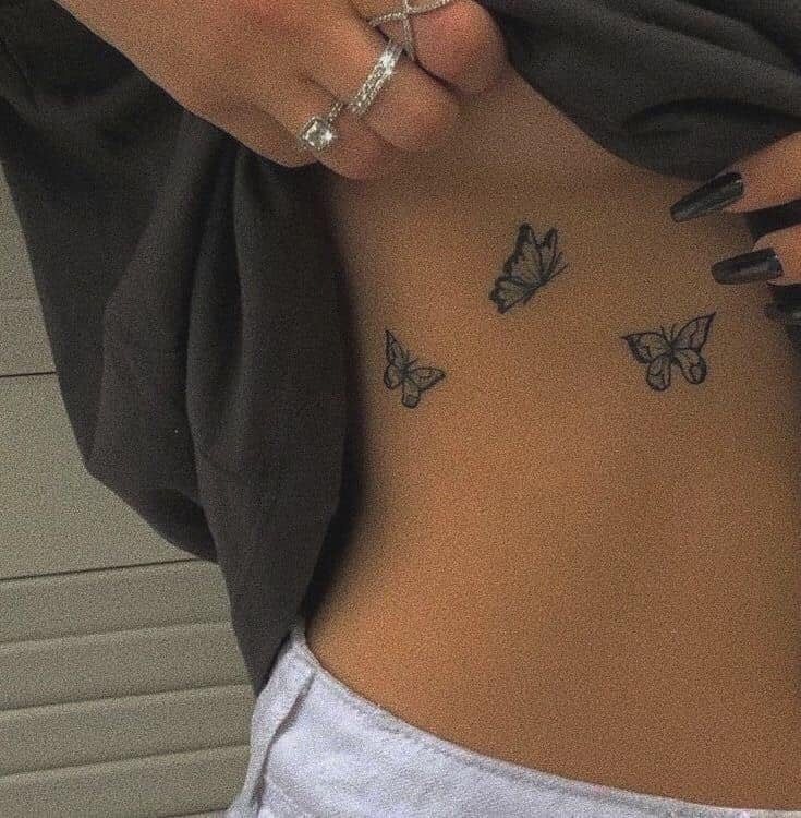 282 Trois tatouages de papillons délicats noirs sous la poitrine