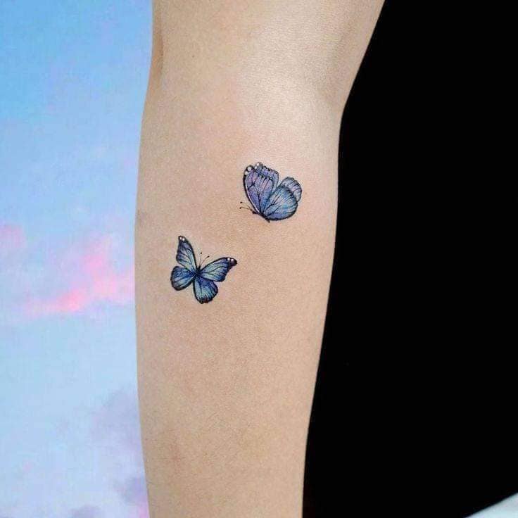 Tatuajes de Mariposas Pequenas y Delicadas dos azules minimalistas en brazo