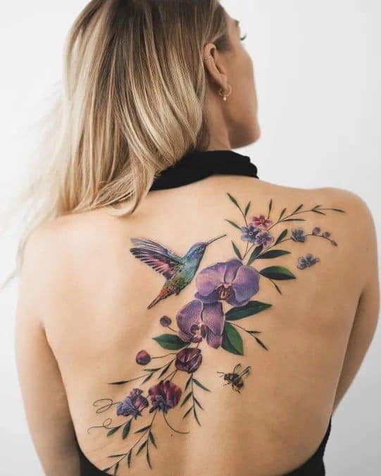 1 TOP 1 Beautiful Women's Back Tattoos Large Branch with Violet Flowers diagonally across the back from the shoulder blade with hummingbird bee leaves art
