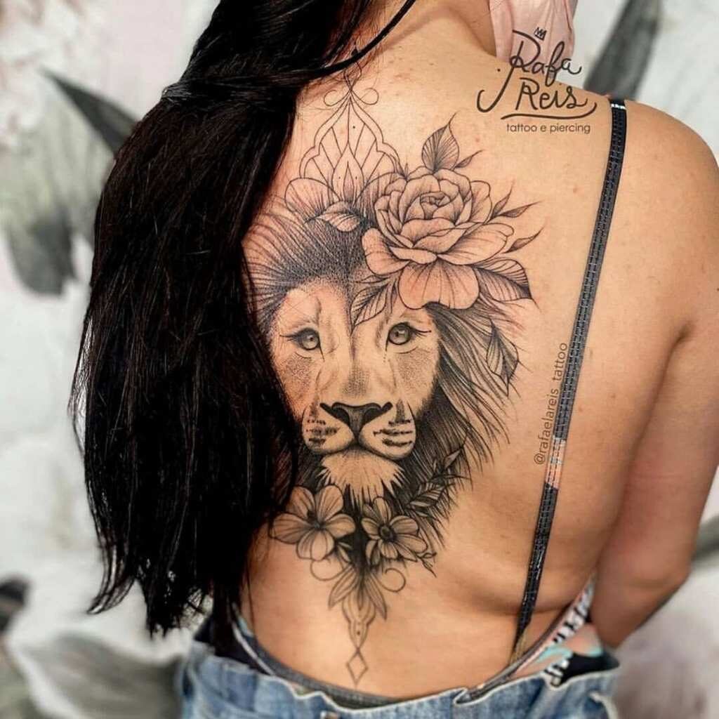 16 Tattoos on the Back of a Woman's Face of a Lion on a full back with roses, long hair, flowers in black