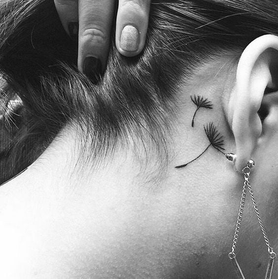16 Tattoos hinter dem Ohr. Zwei fliegende Löwenzahnsamen