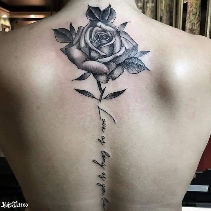 193 Tatuajes en la Espalda Mujer Rosa Negra debajo de la nuca con tallo con inscripcion en la columna